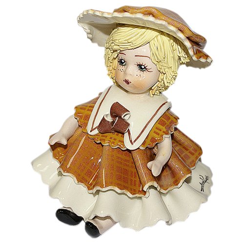 Фарфоровая статуэтка Девочка сидящая со светлым волосами в коричневом платье